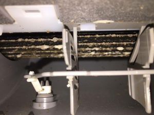 Szakember ellenőrzi és tisztítja a klímaberendezés beltéri egységét, hogy a légkondicionáló hatékonyan és megbízhatóan működjön.